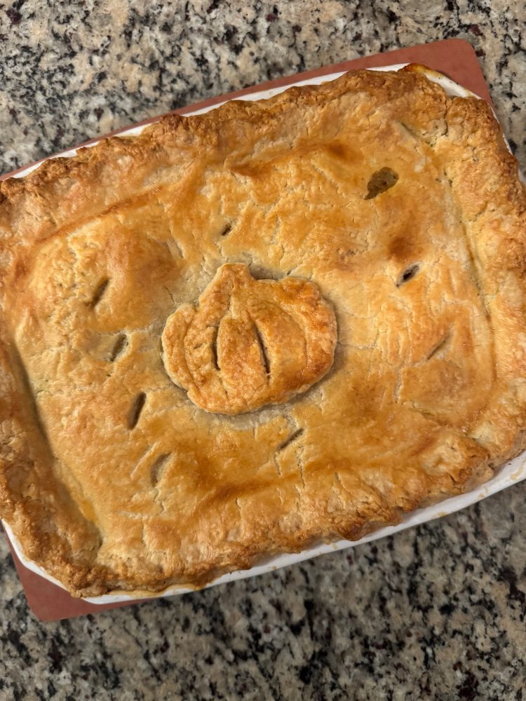 Recipe Photo for Our Favorite Chicken Pot Pie recipe.  Overhead shot of pot pie in rectangular baker.  Crust is golden brown with small cuts to release steam and a decorative pumpkin on top the crust.  The dish is on a granite countertop