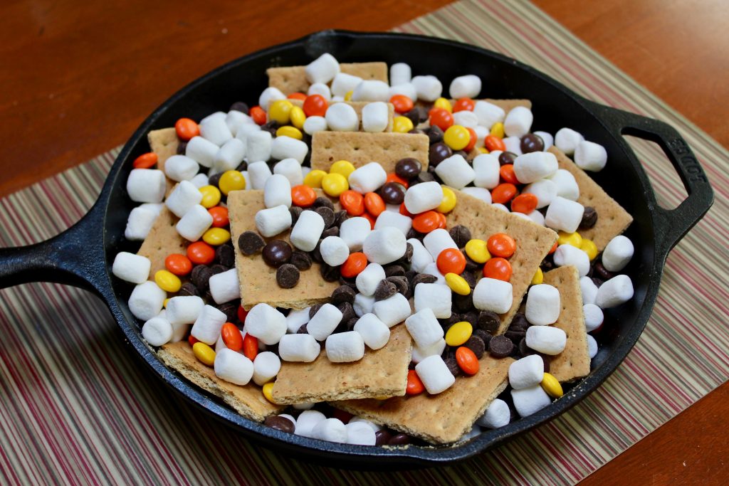 Layer the graham crackers, chocolate chips, peanut butter candies and mini marshmallows in 10" black cast iron Lodge skillet