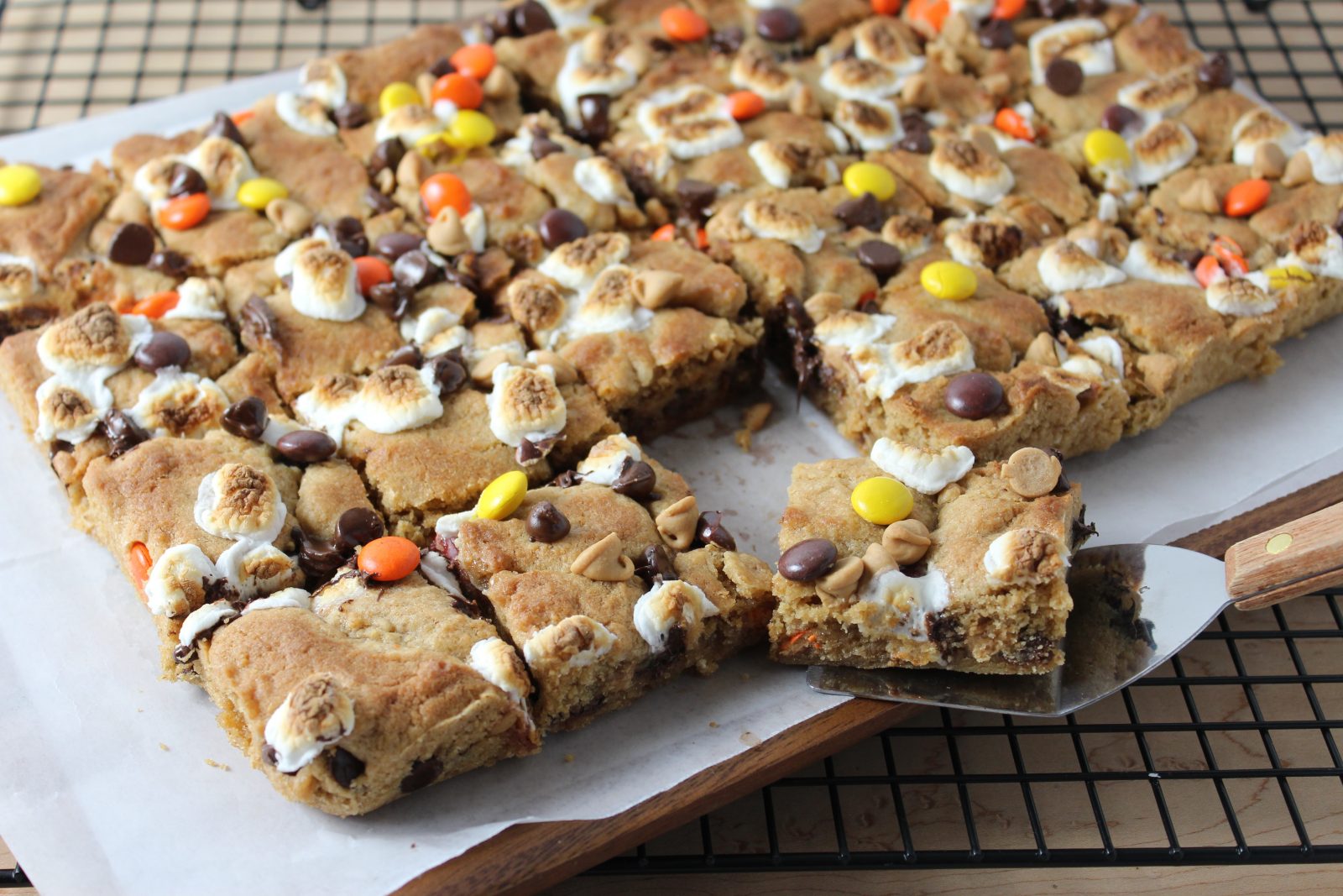 Peanut Butter S'mores Cookie Bars - close up photo of bars cut and one on spatula