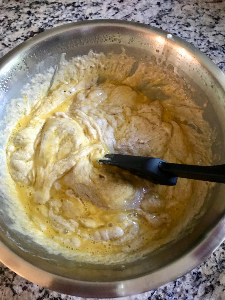 Making yeasted waffle batter, stirring in the egg and baking soda after an overnight rise