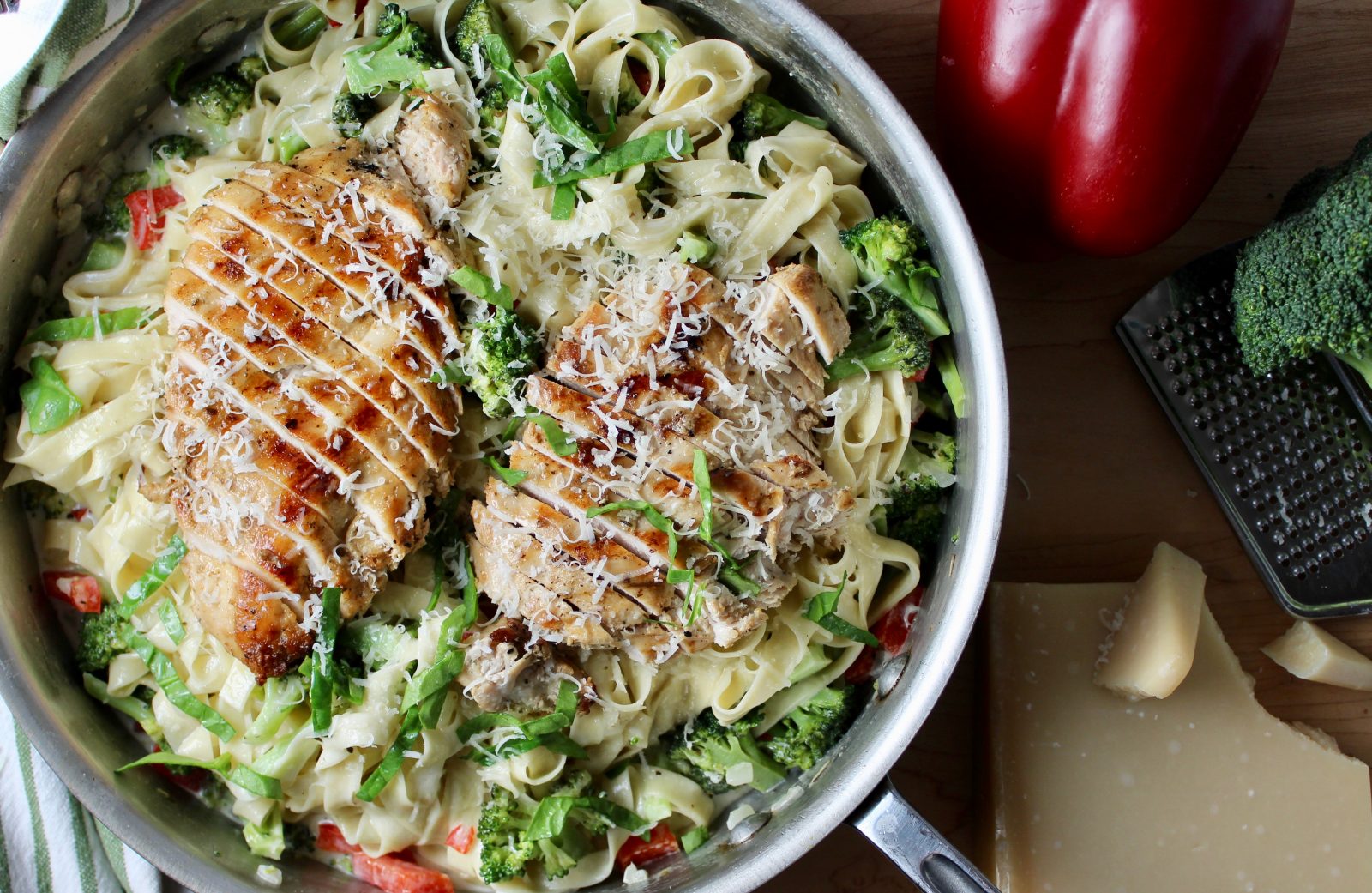 All-Clad Large Skillet filled with fettuccini in Parmesan cream sauce, with broccoli, red pepper and topped with sliced grilled chicken