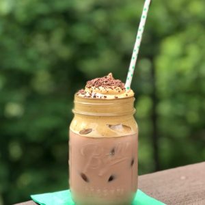 mason jar with whipped mocha coffee, green dotted paper straw