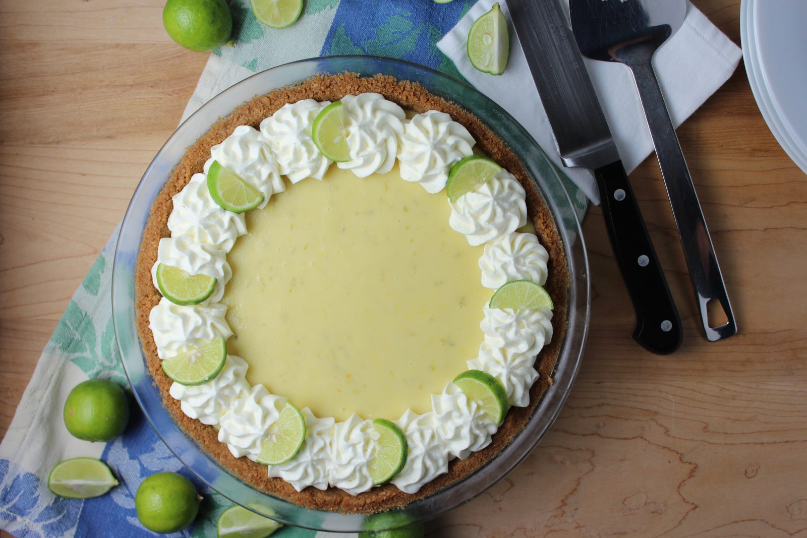 key lime pie with whipped cream rosettes and key lime slices around edge of pie