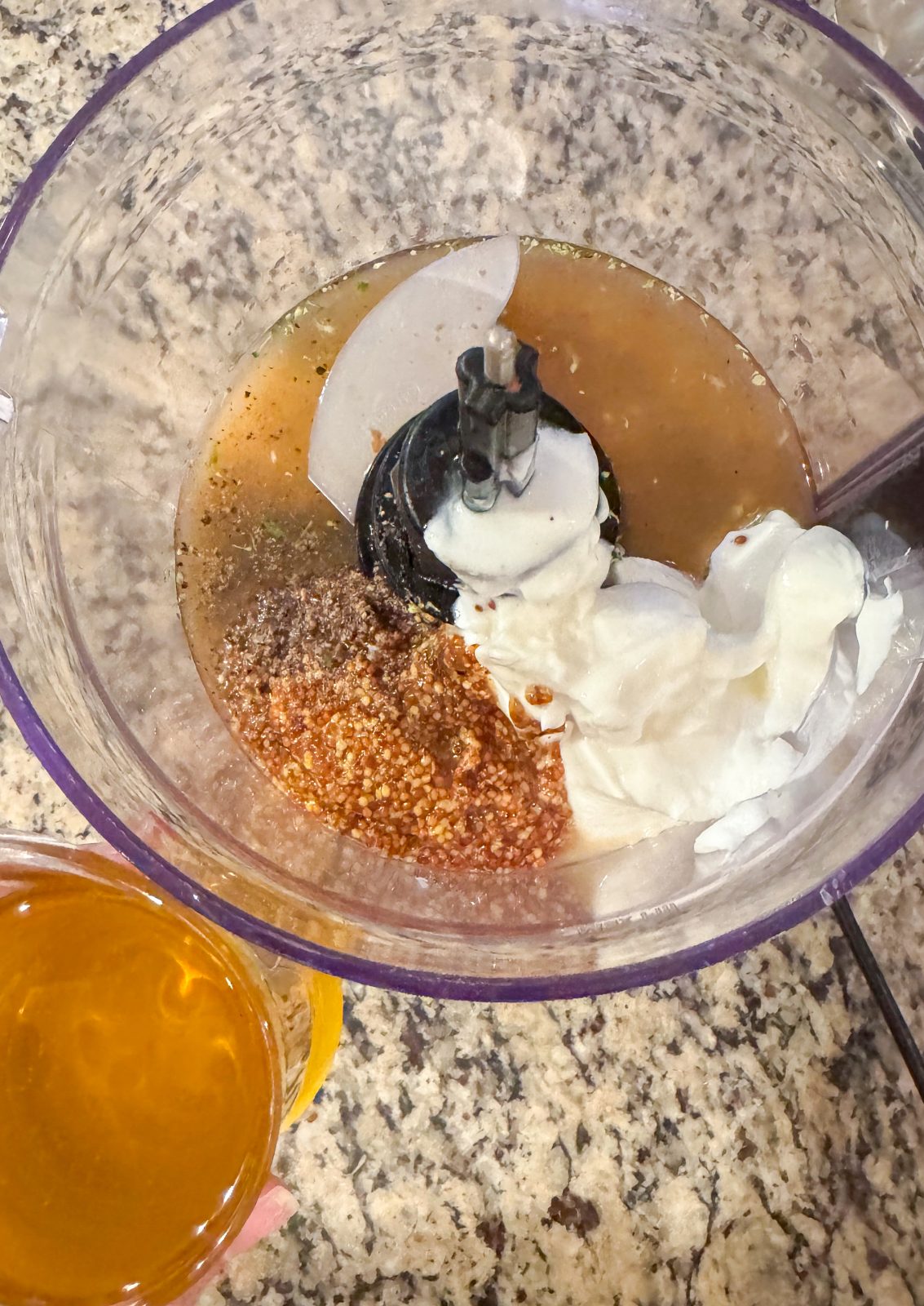 Ingredients for Creamy Honey Mustard Dressing in KitchenAid 7-cup Food Processor. Greek yogurt, whole grain dijon mustard, apple cider vinegar and some olive oil in a measuring cup to the side.