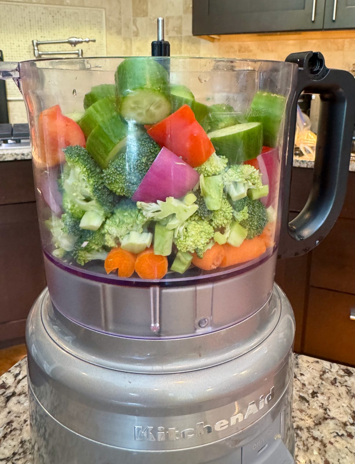 Vegetables layered in KitchenAid 7-cup Food Processor: carrot, broccoli, red onion, red pepper and cucumber. Ready to be chopped to make Creamy Honey Mustard Pasta & Chicken Salad
