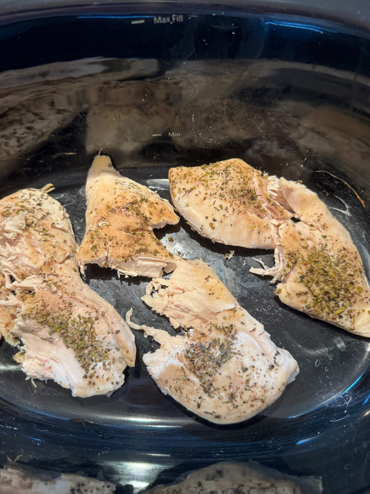 Recipe Photo for Marry Me Chicken Dip Showing 5 cooked chicken breasts in a black oval slow cooker.