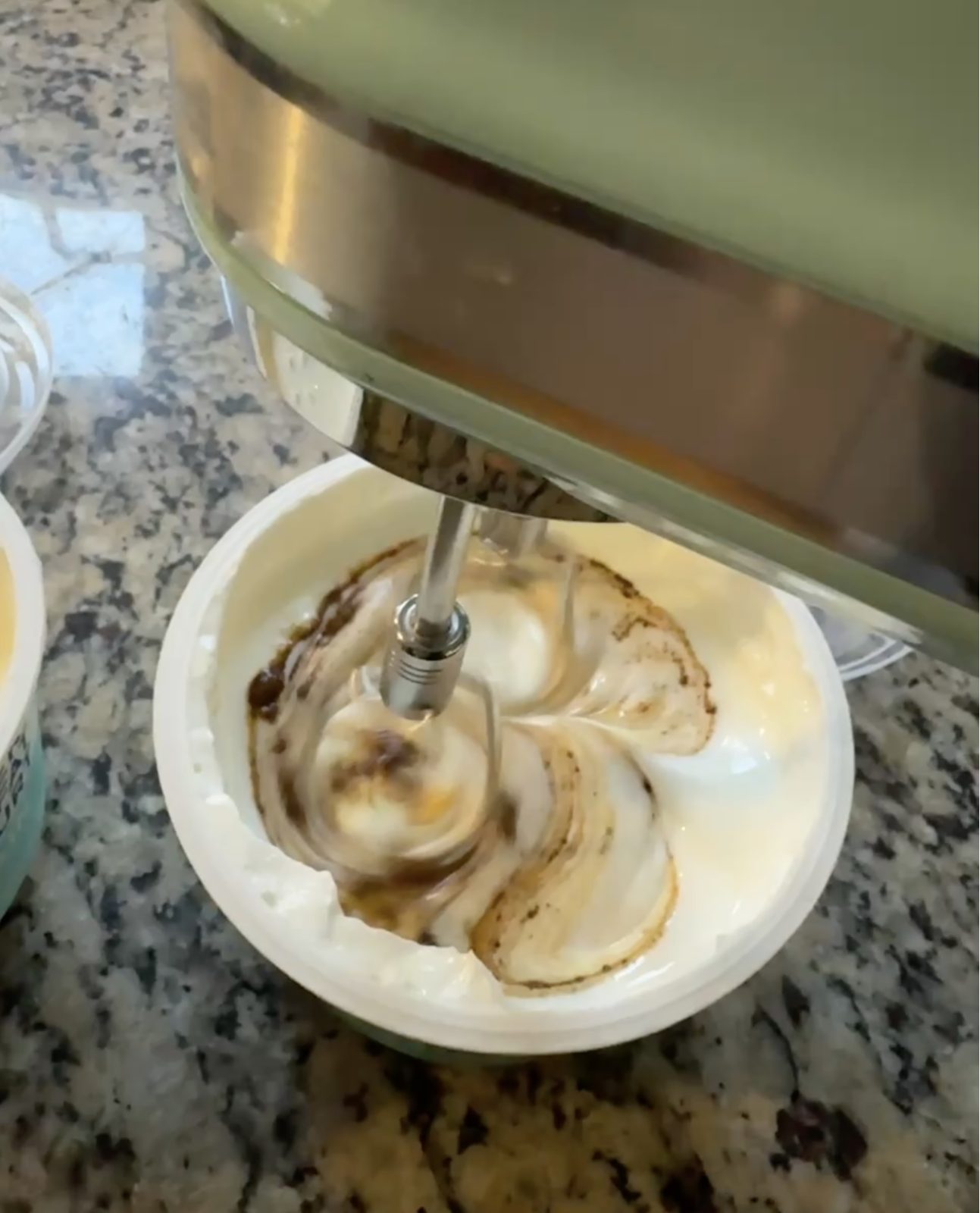 recipe image for Viral Greek Yogurt Biscoff Cheesecake (tiramisu version) Shows top KitchenAid Hand Mixer - mixing espresso powder into tub of plain greek yogurt